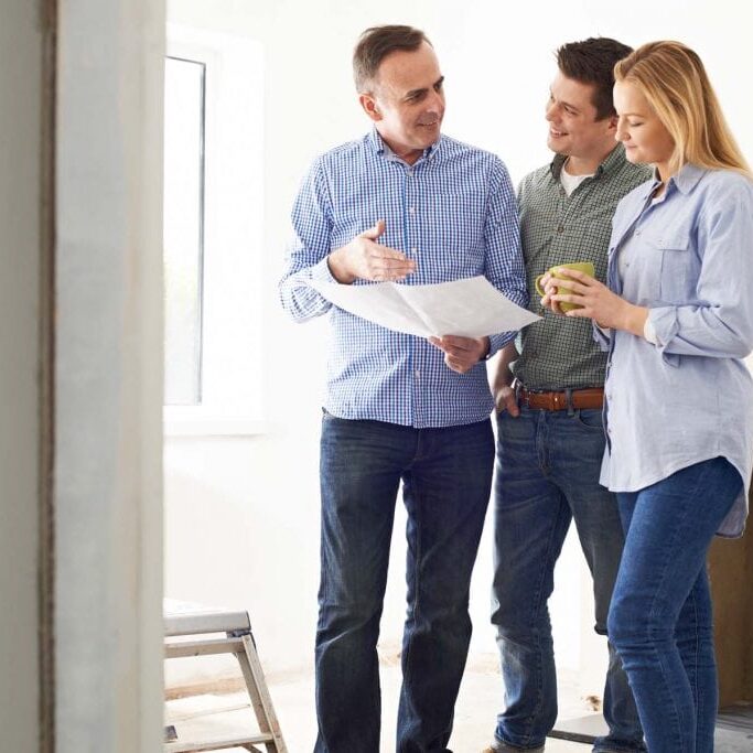 Couple Meeting With Architect Or Builder In Renovated Property